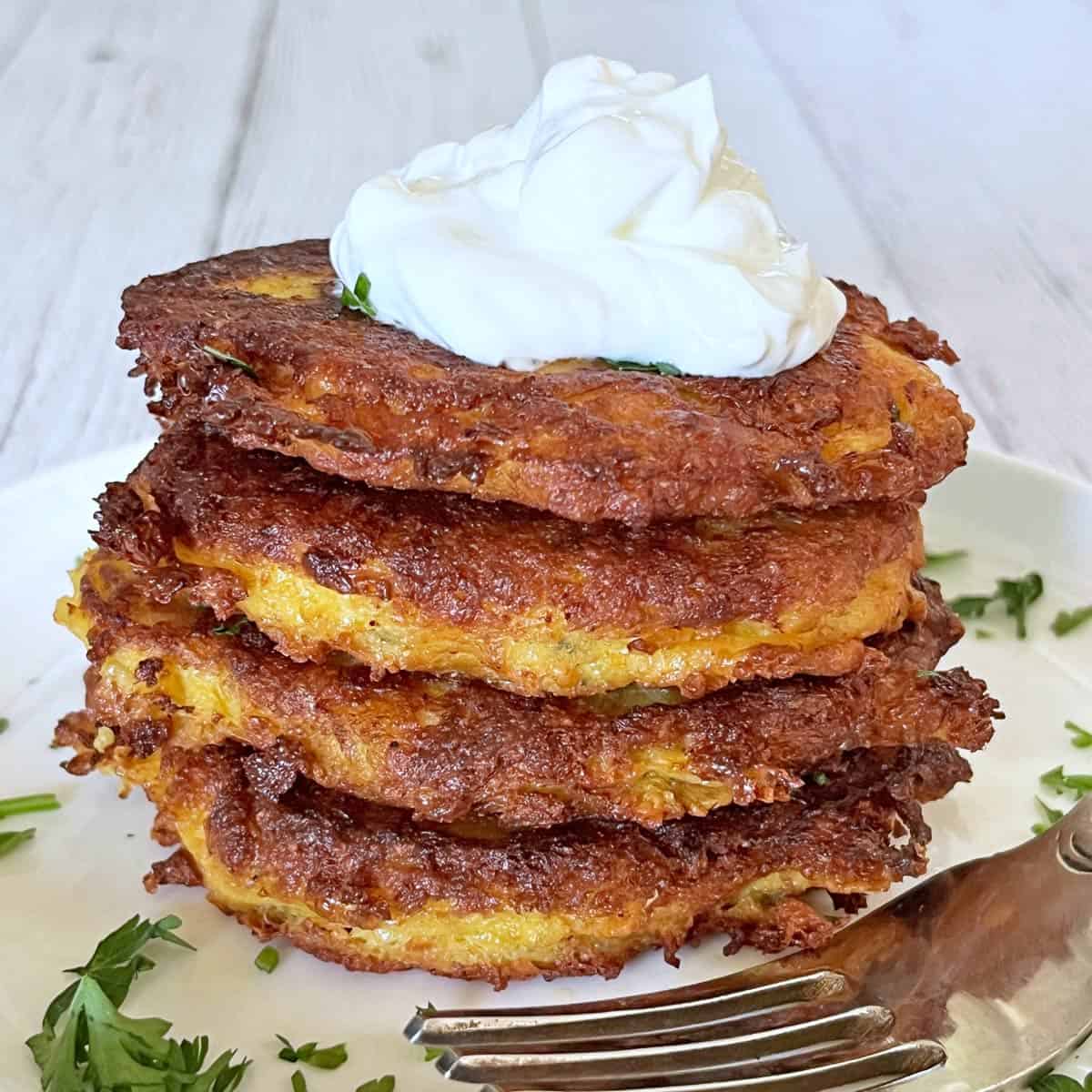 Spaghetti squash fritters are topped with sour cream.