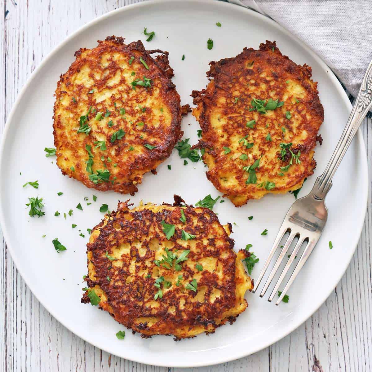 Three spaghetti squash fritters on a plate.