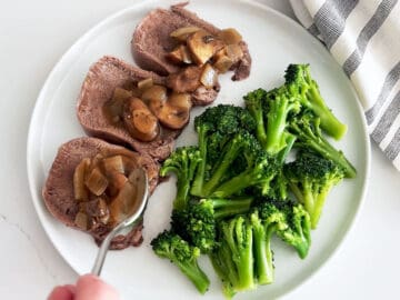 Topping tongue slices with the sauce. They are served on a plate with broccoli.