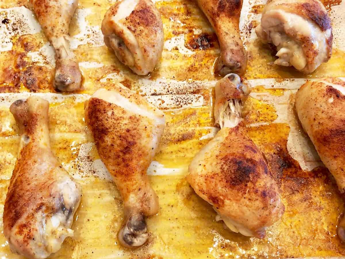 The drumsticks are fully baked on the baking sheet.