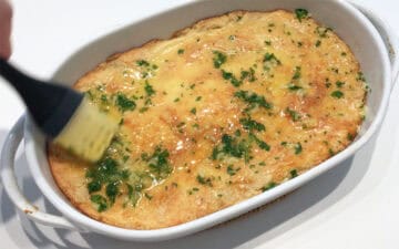 Brushing the bread with the butter mixture.