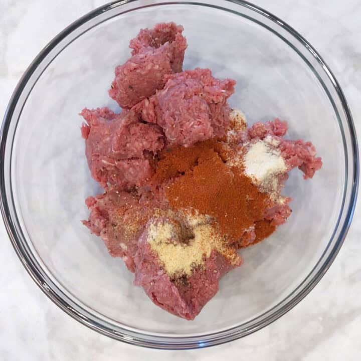Ground beef and spices in a bowl.