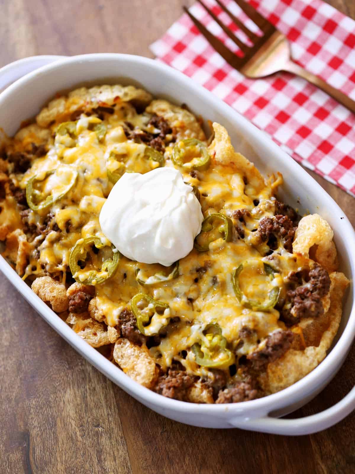 Keto nachos are topped with sour cream.