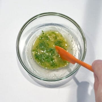 Mixing melted butter with garlic and parsley.
