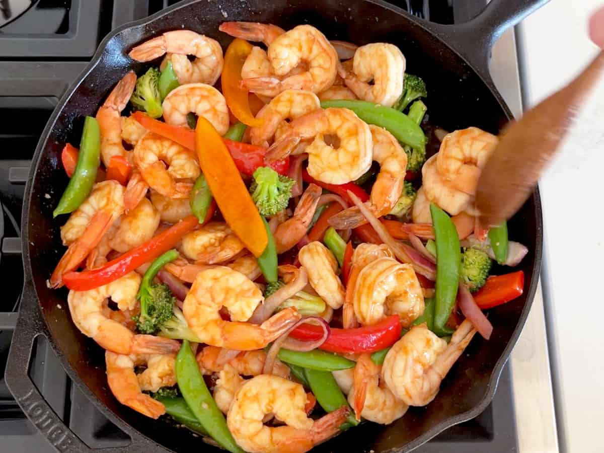 Adding the shrimp and sauce to the skillet.