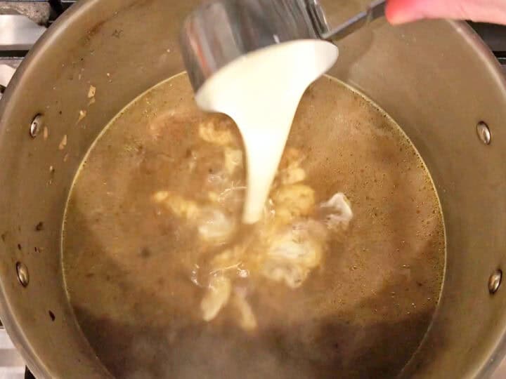 Adding cream to the stockpot.