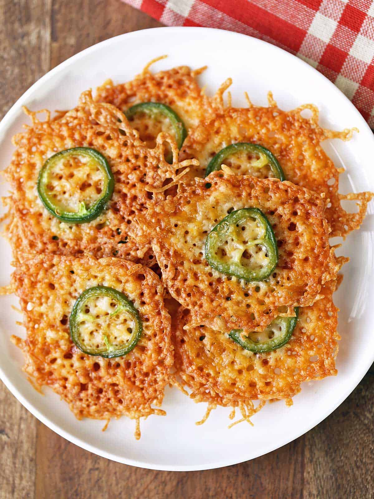 Cheese crisps are piled on a plate.