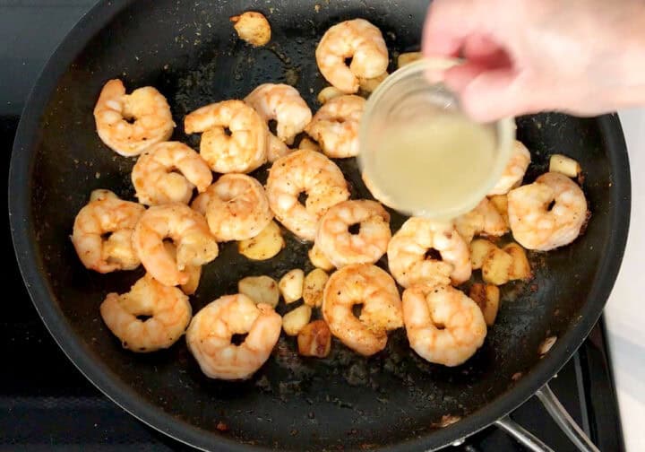 Adding lemon juice to the skillet.