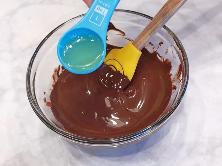 Adding oil to the melted chocolate.