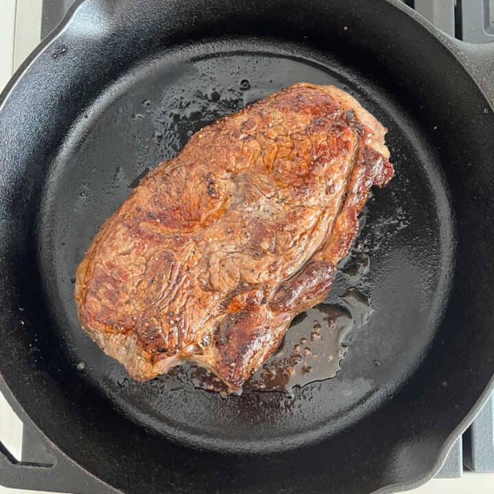 Cooking the steak in a skillet.