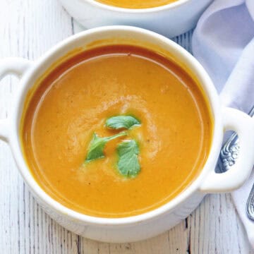 Pumpkin curry soup is served in a white bowl.