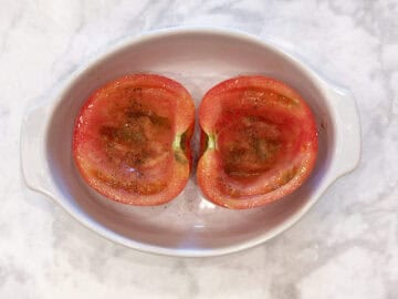 Oiled and seasoned tomatoes in the baking dish.
