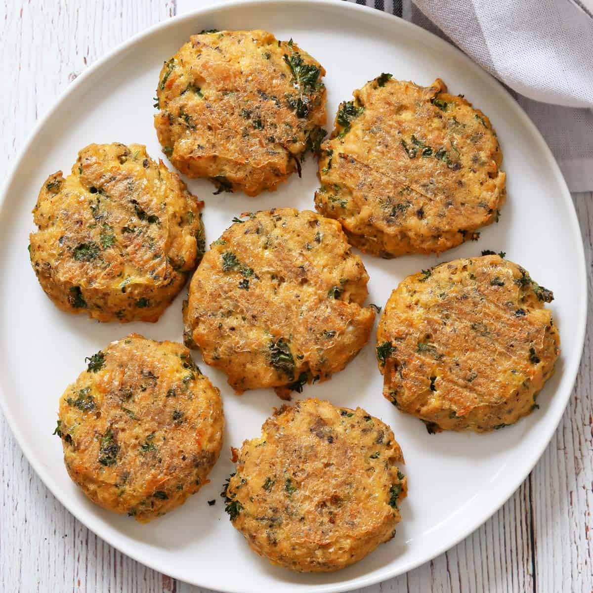 Baked salmon cakes are served on a white plate.
