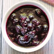 Blueberry compote is served in a white bowl.