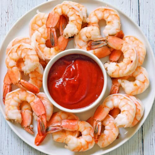 Boiled shrimp are served with a cocktail sauce.