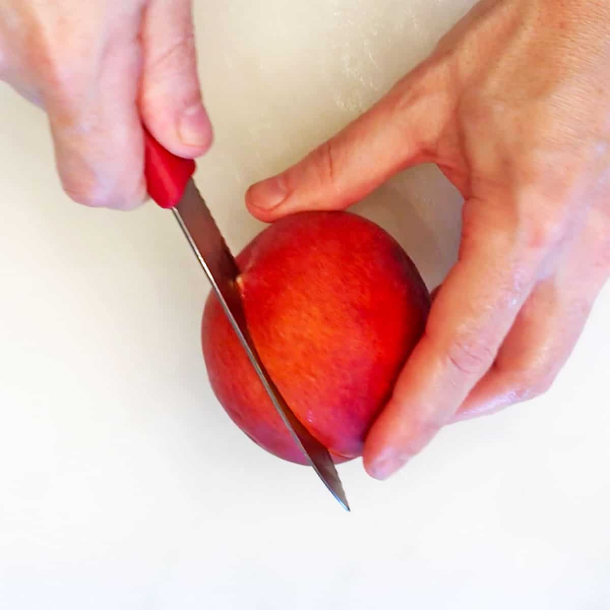Cutting a peach in half.