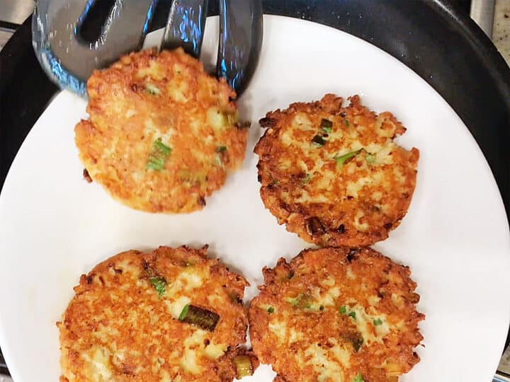 TRansferring the fritters from the skillet to a plate.