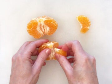 Dividing the orange into segments.
