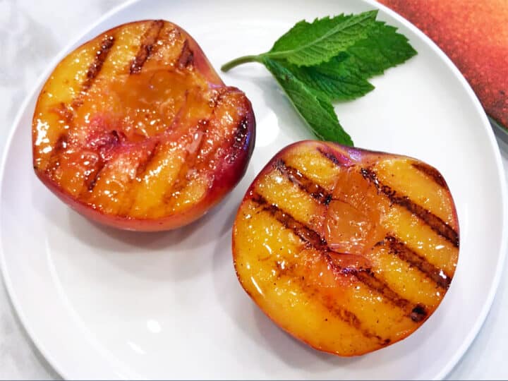 The peaches are served on a white plate.