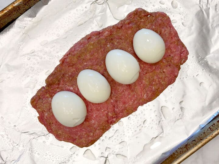 Topping the bottom beef layer with hard-boiled eggs.