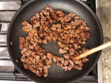 Adding garlic and spices to the ground beef.