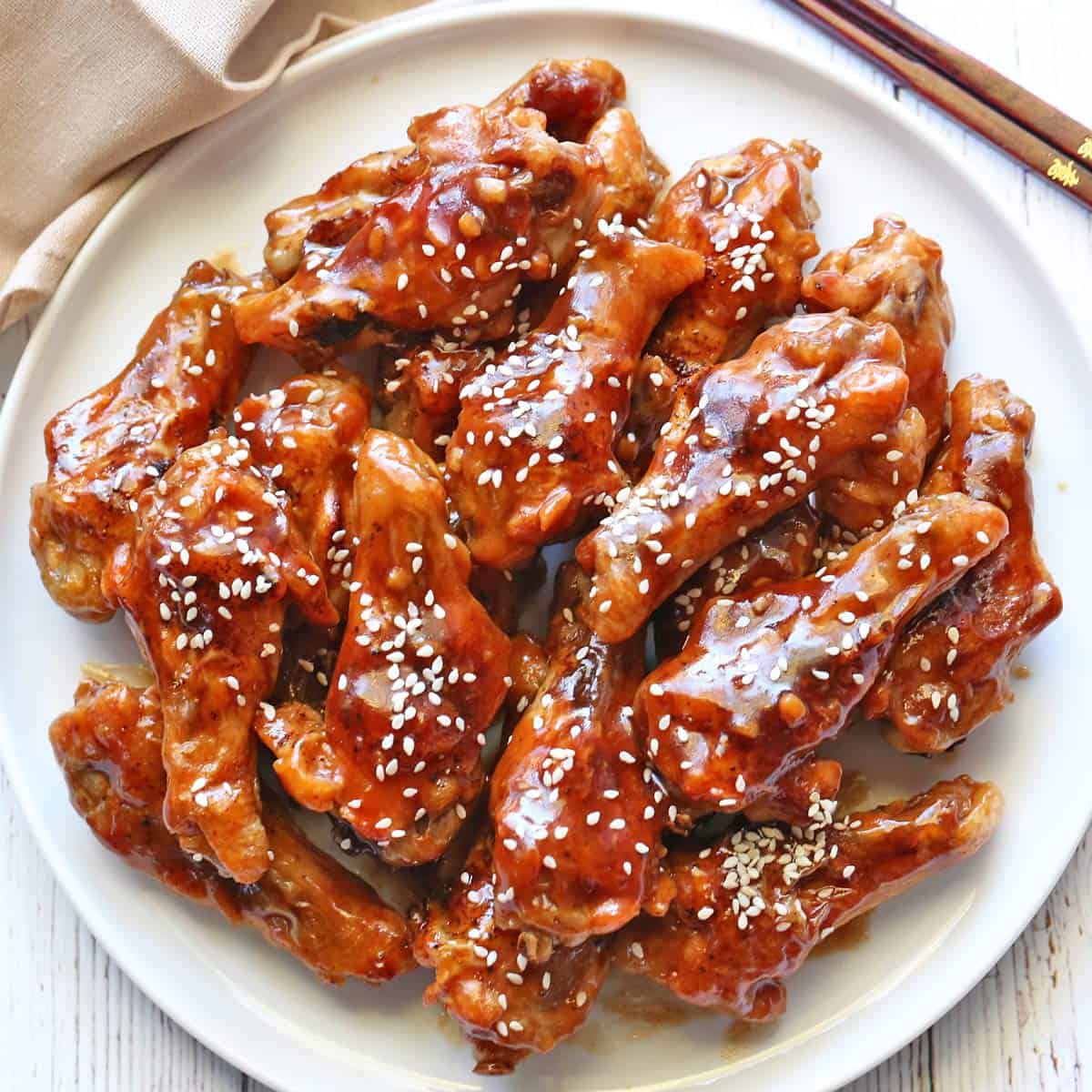 Teriyaki wings are served on a white plate.