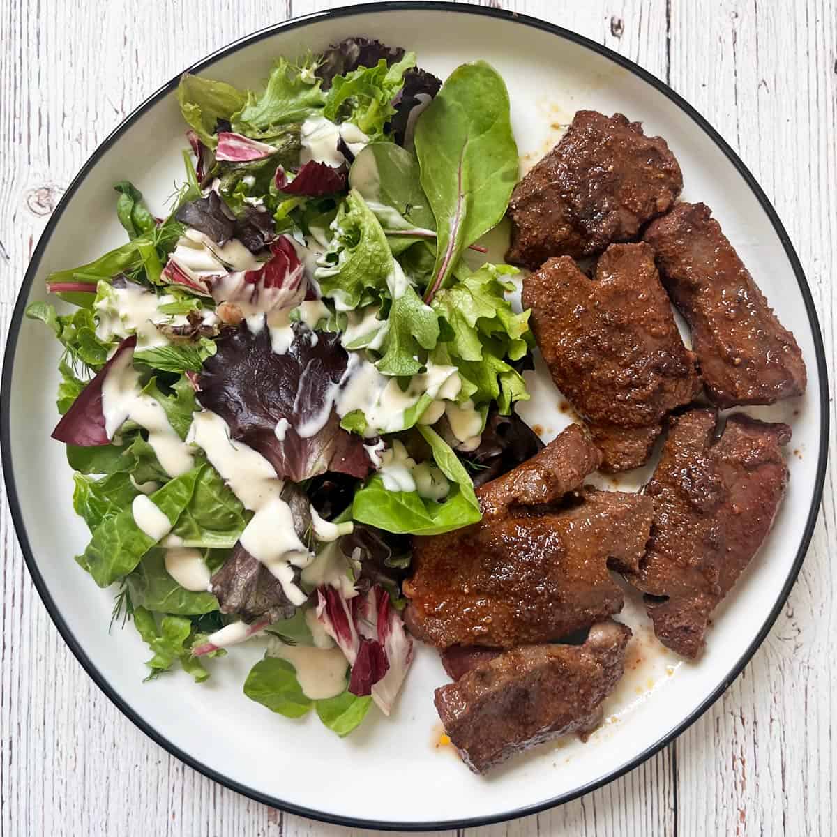 Pan-fried beef heart is served with a salad.