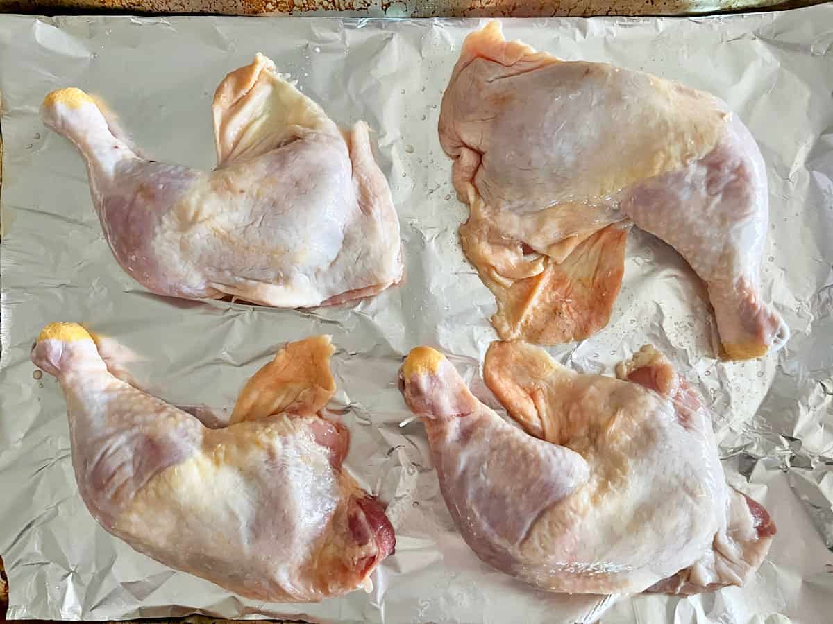 The chicken leg quarters are in the pan.