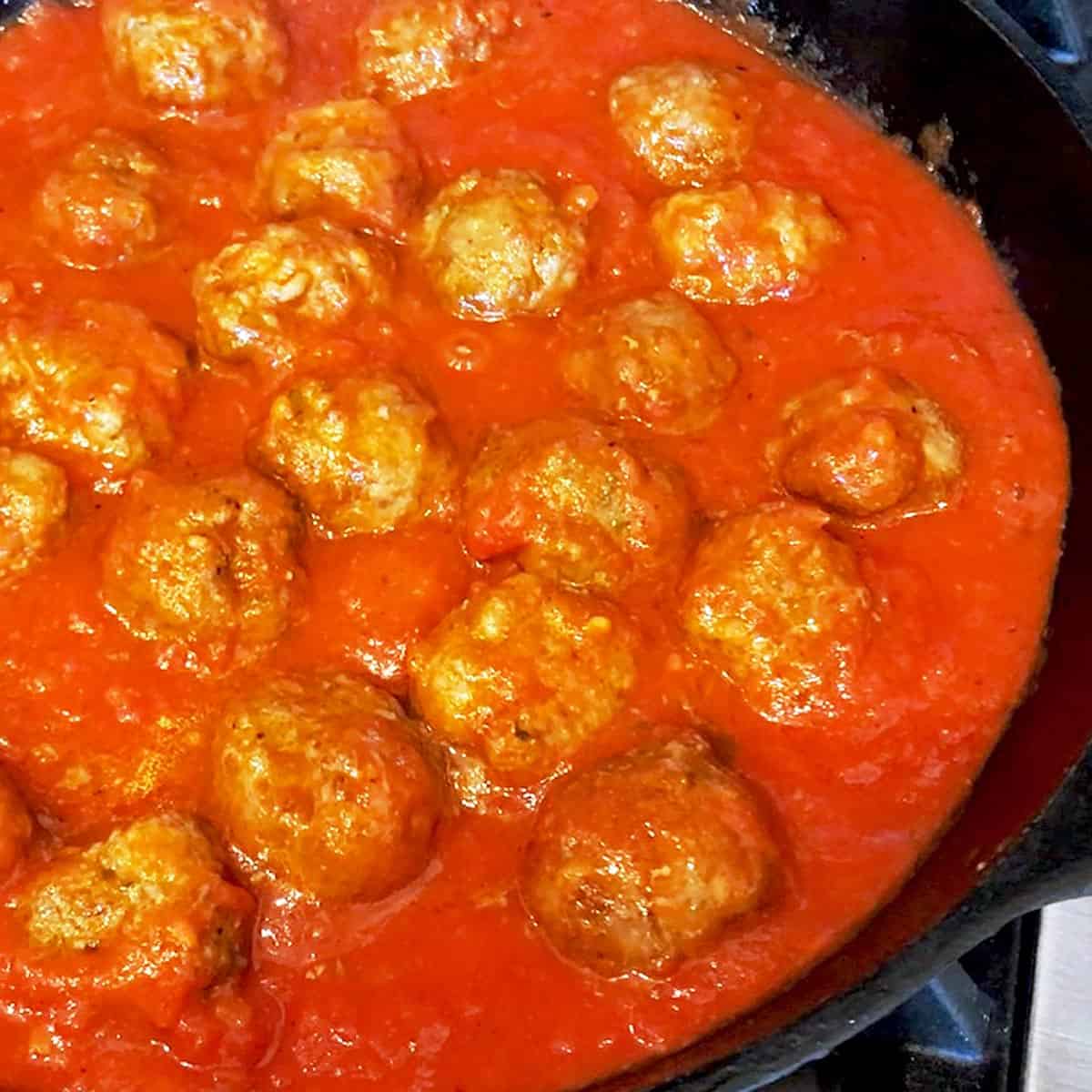 Cooking the meatballs in the marinara sauce.