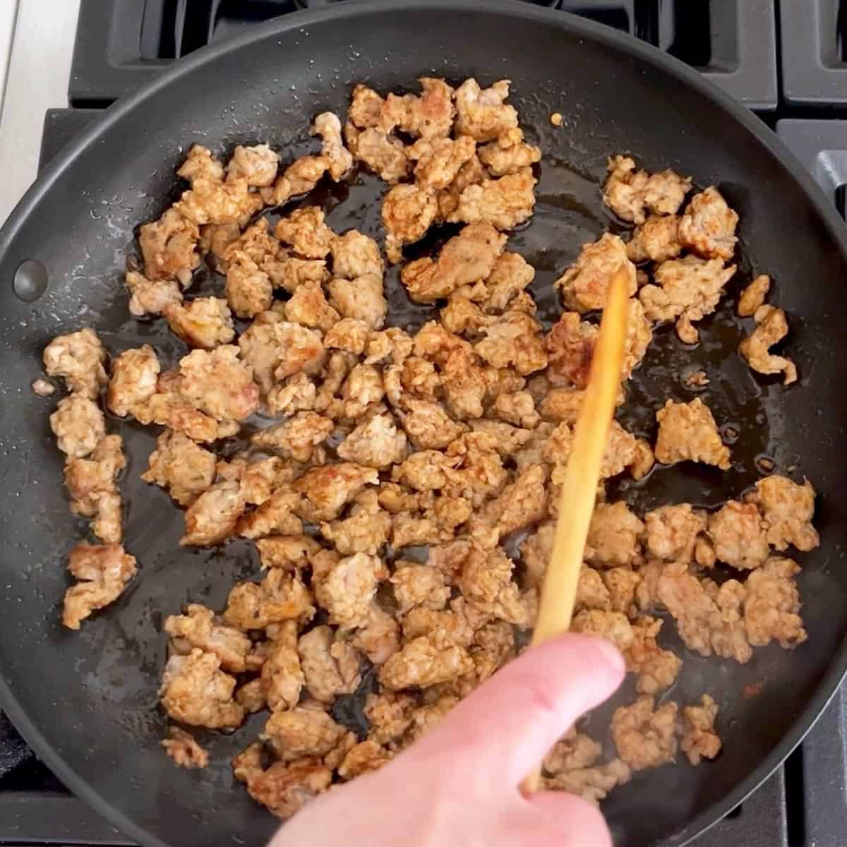 Cooking sausage in a skillet.