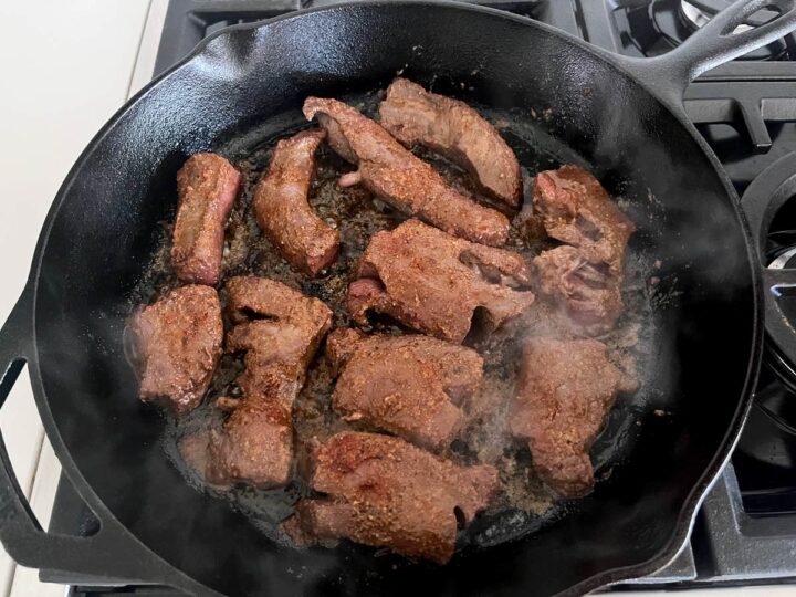 Pan-frying beef heart in a skillet.