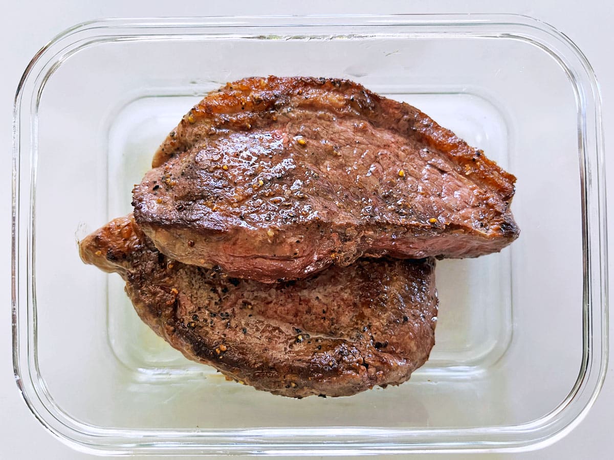 Picanha steak leftovers are stored in a glass food storage container.