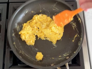 Scrambling eggs in a skillet.