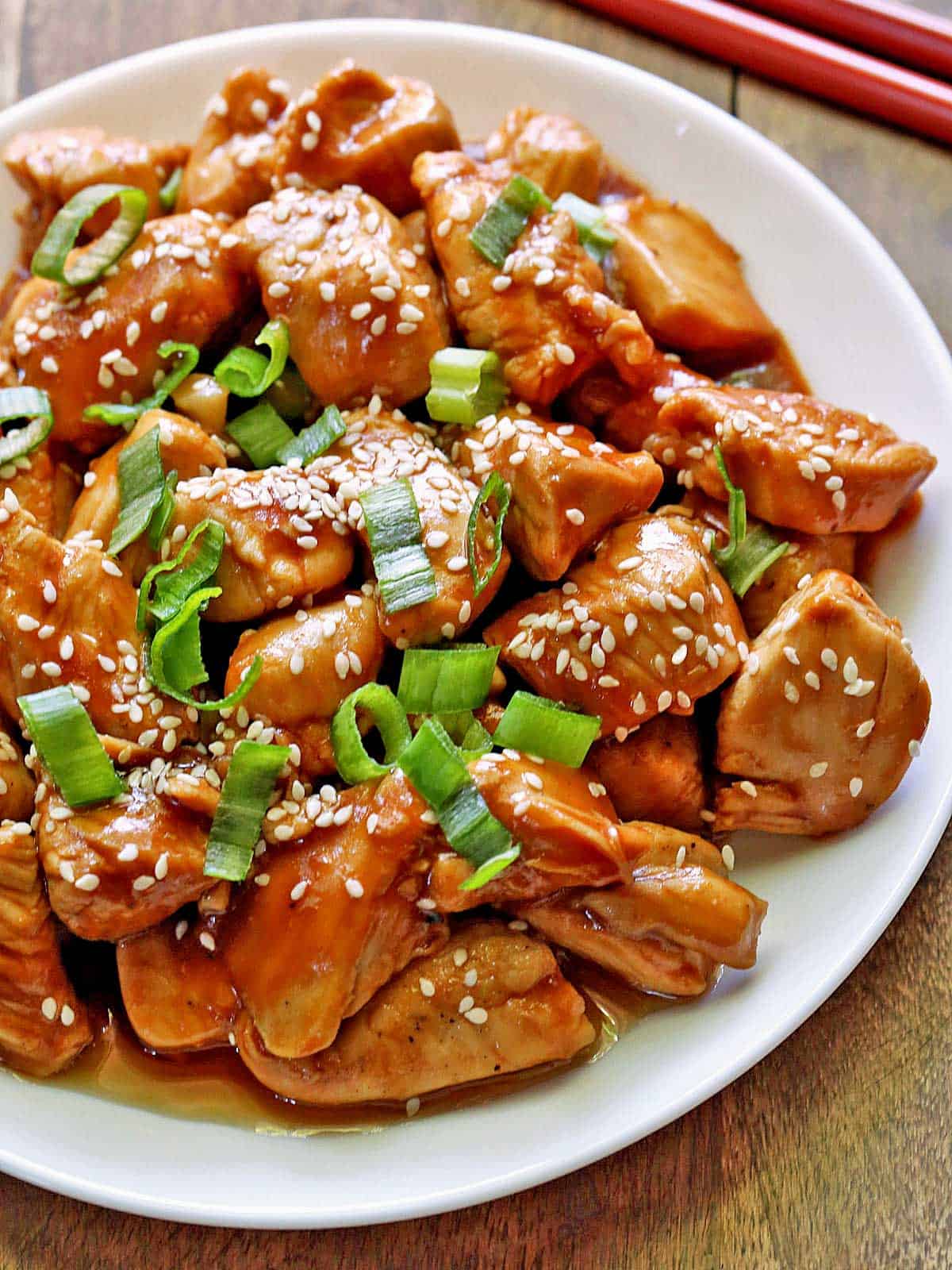Keto sesame chicken is served on a white plate.