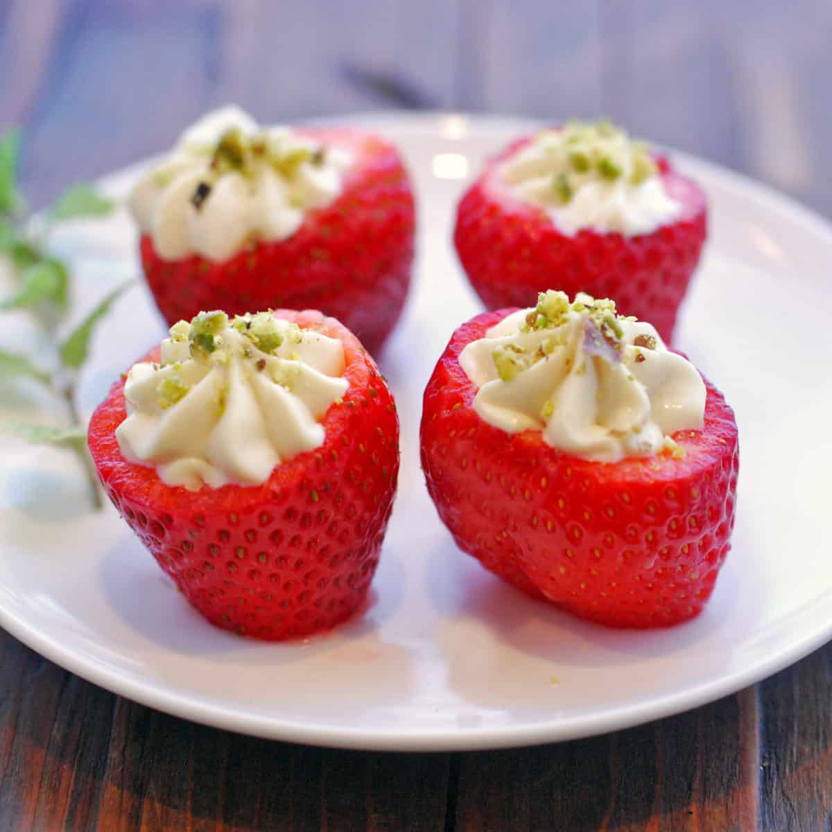 Cheesecake stuffed strawberries are topped with nuts.