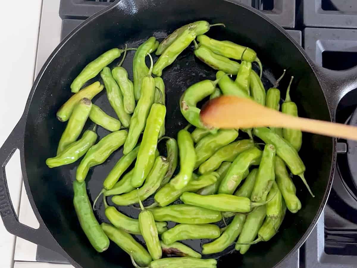 Cooking the peppers in a skillet.