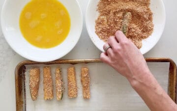 Coating the fries in the Parmesan mixture.