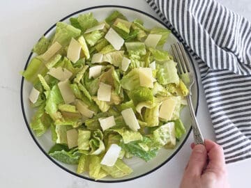 The salad is served with a napkin and a fork.