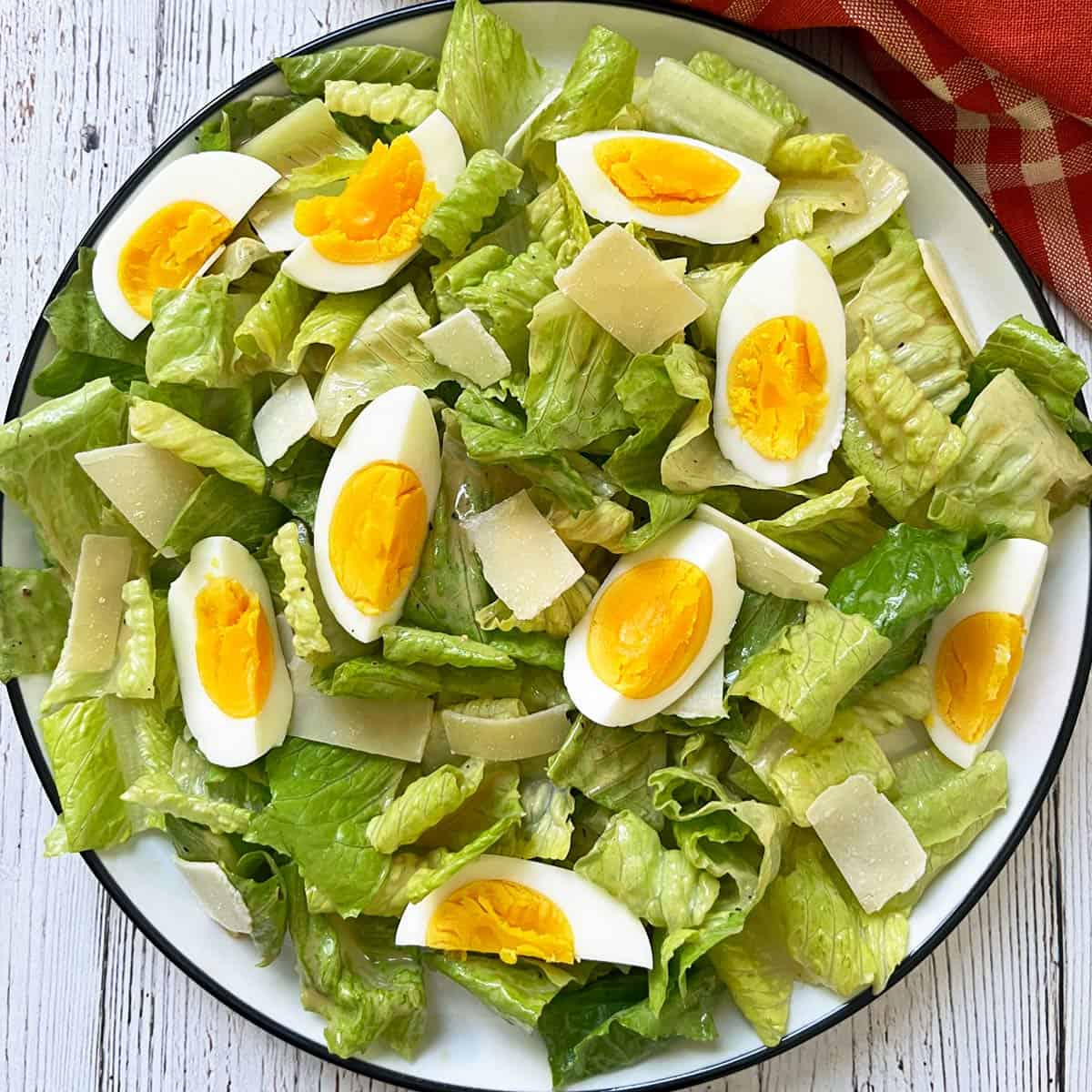Caesar salad is topped with eggs.