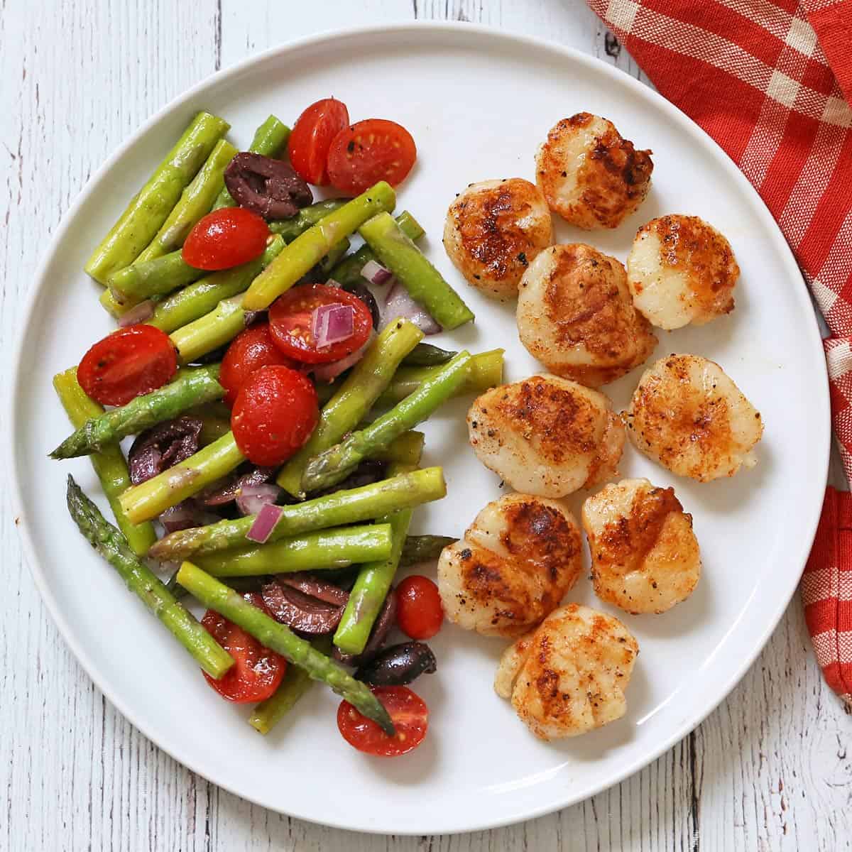 Grilled scallops are served with asparagus salad.