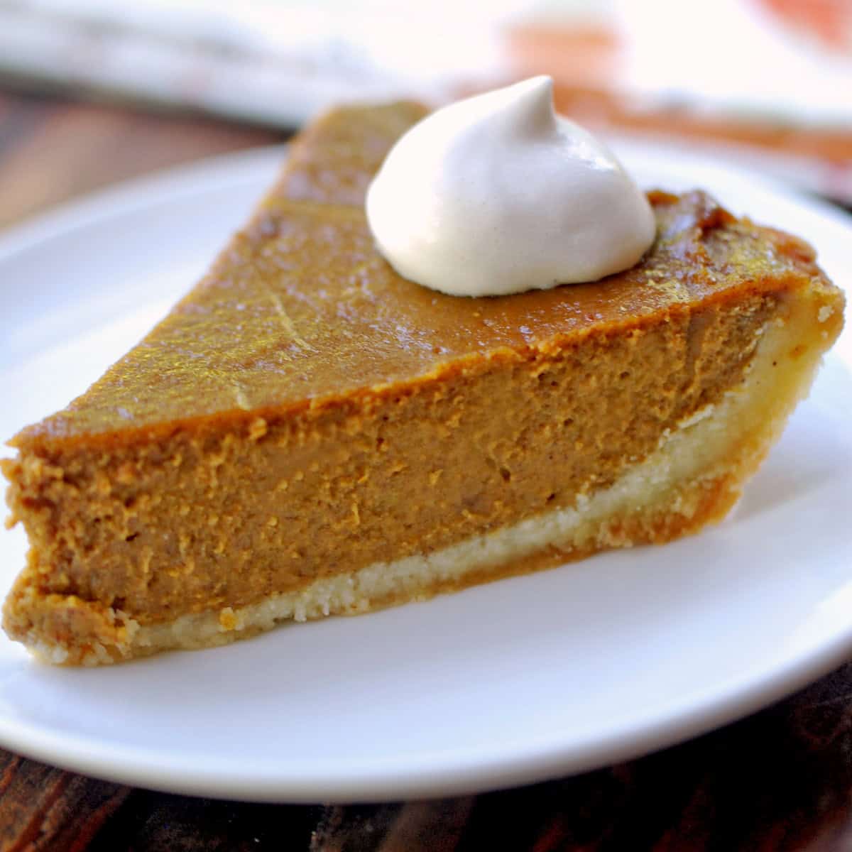 A slice of keto pumpkin pie with an almond flour crust.