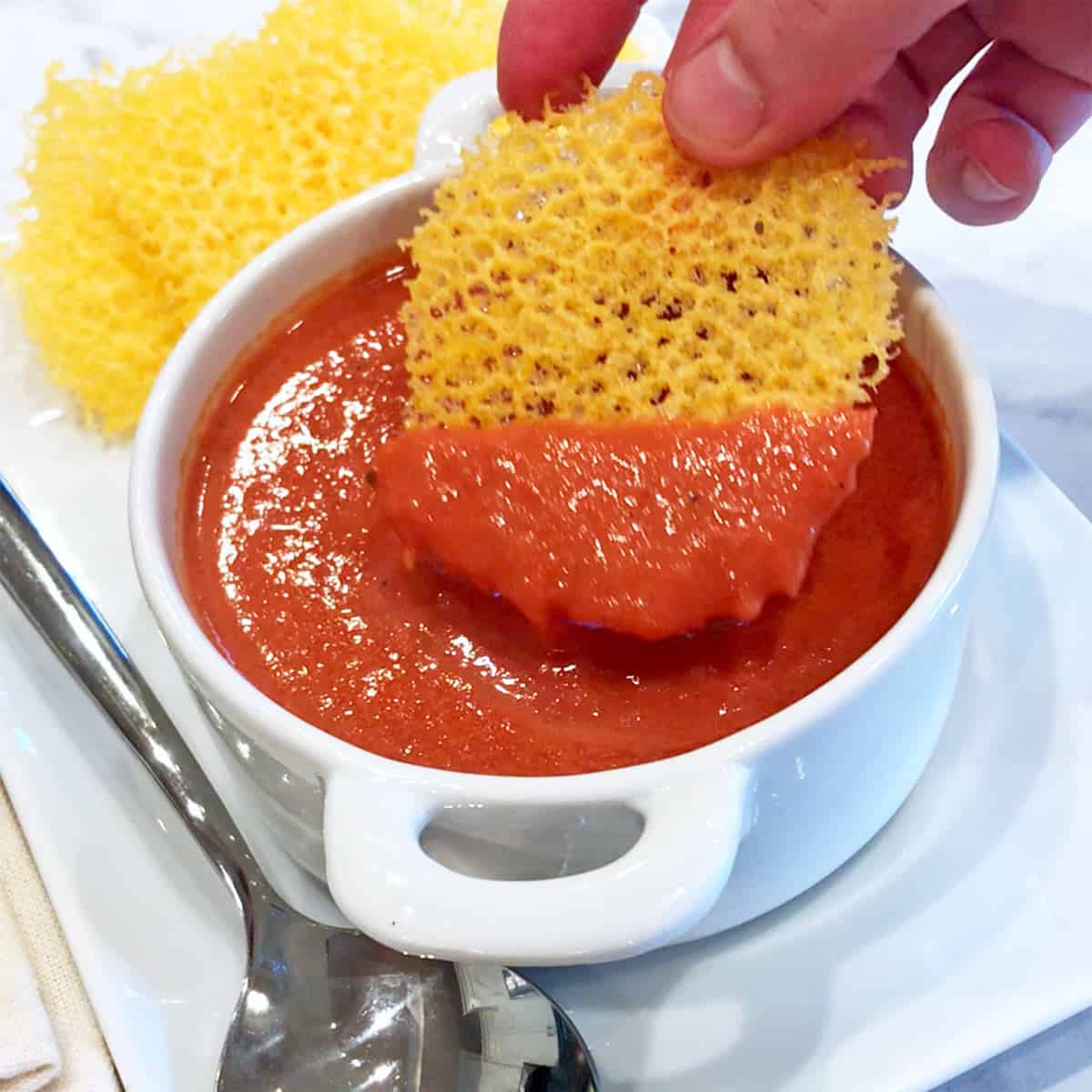Dipping a cheese cracker into tomato soup.