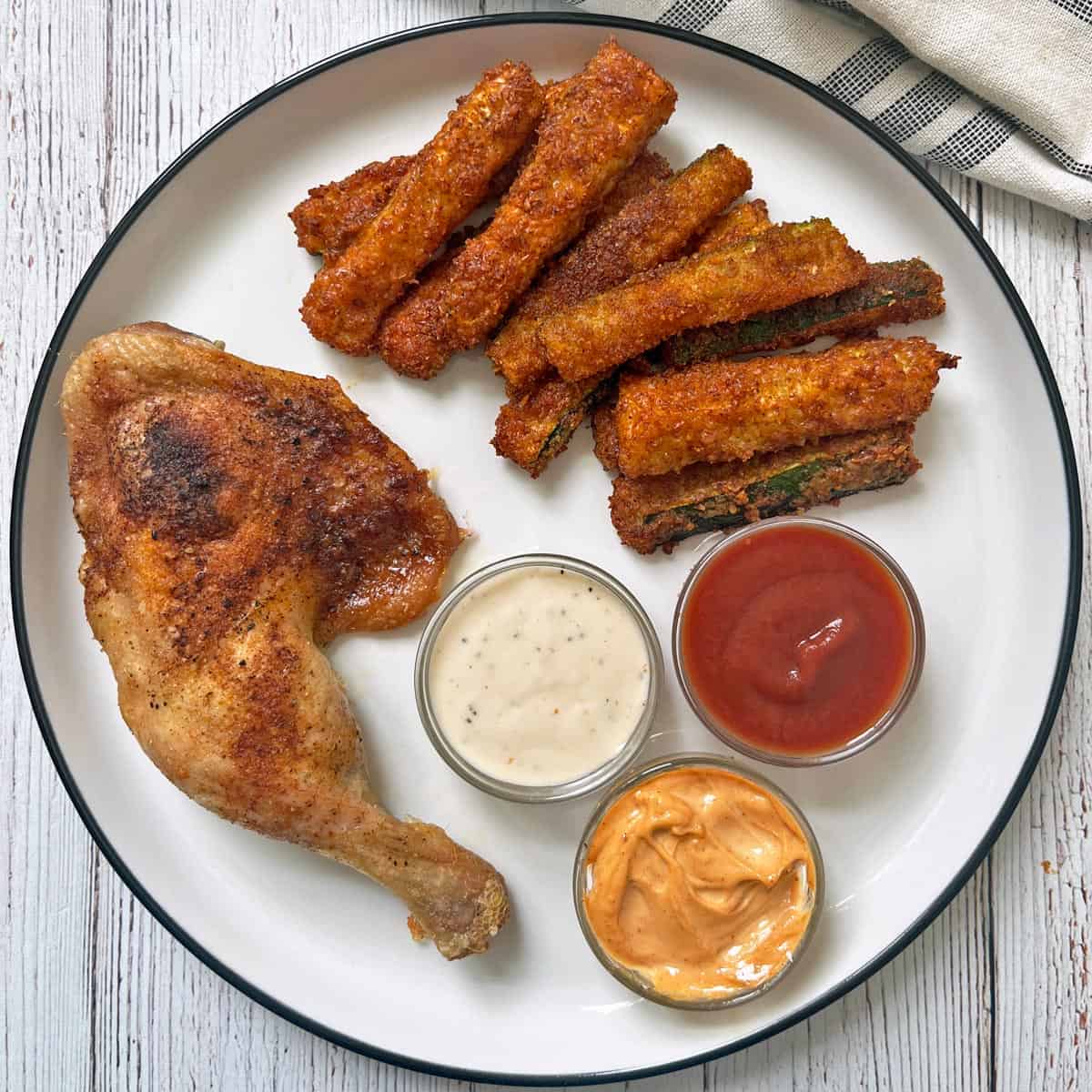 Zucchini fries are served with a chicken leg quarter and dips.