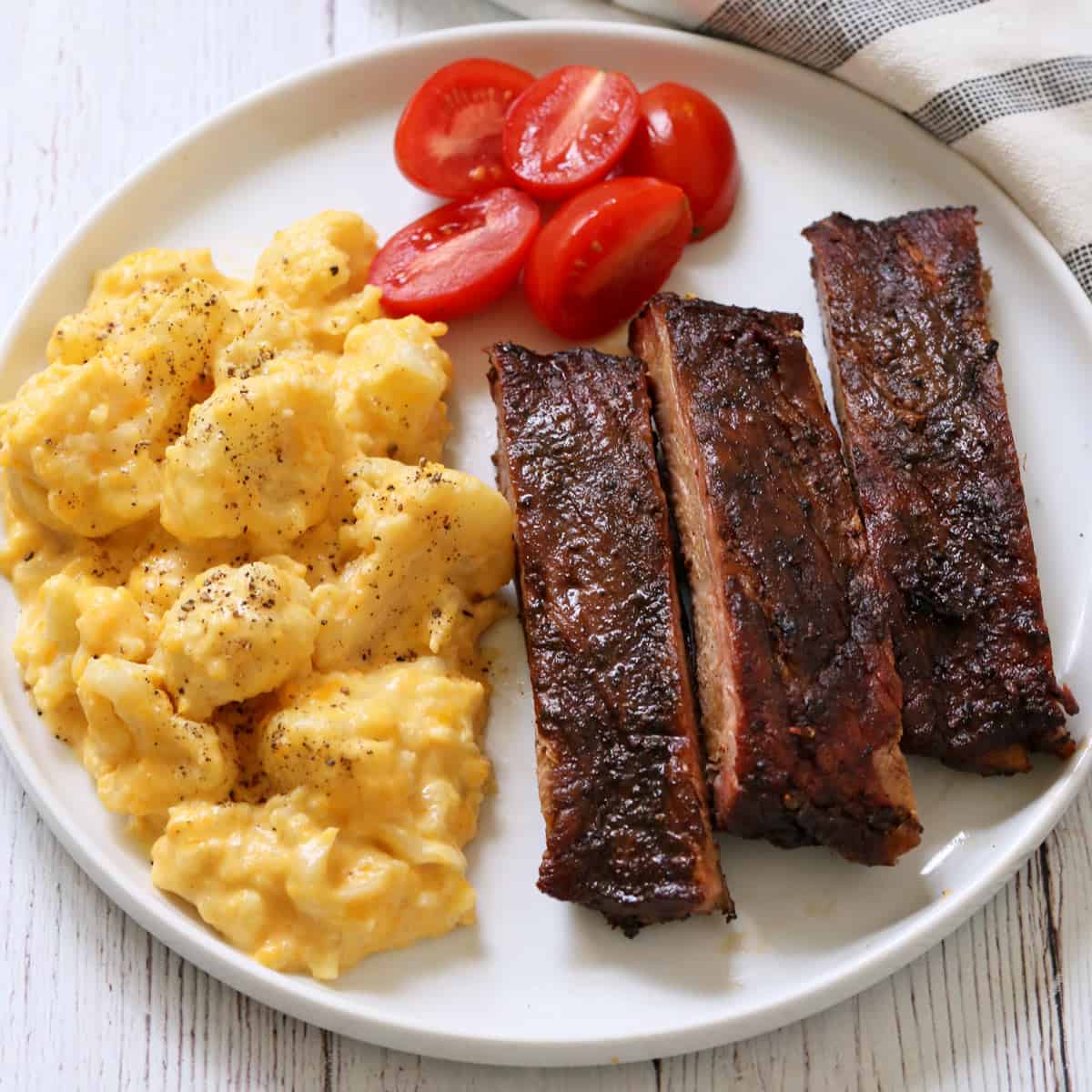 Cauliflower mac and cheese is served with ribs.