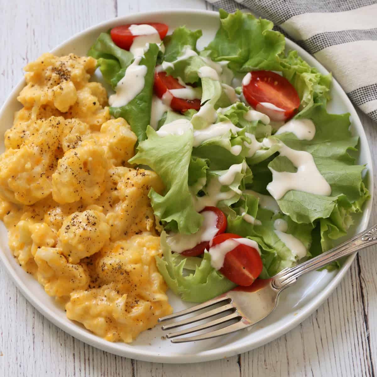 Cauliflower mac and cheese is served with a salad.