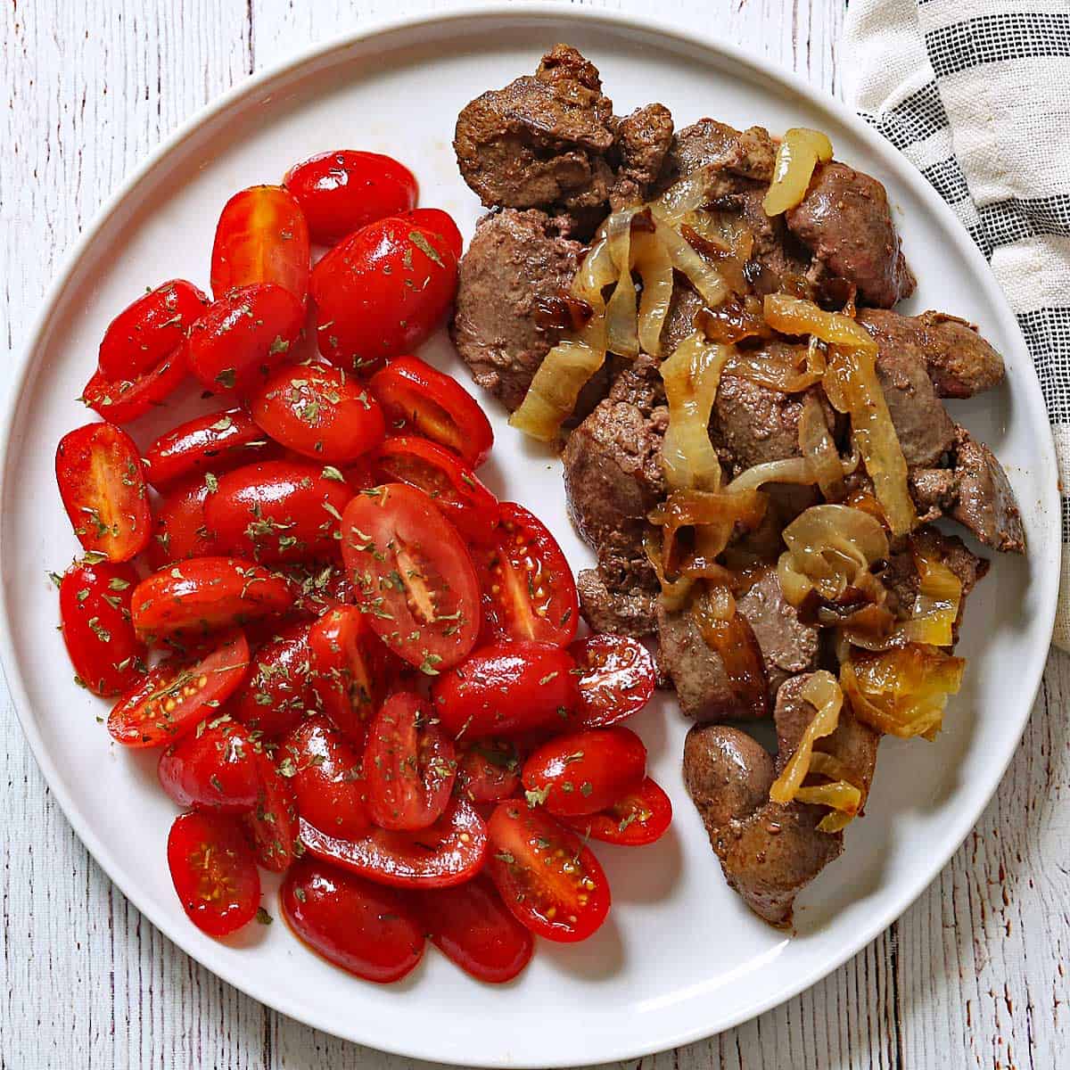 Chicken livers are served with tomato salad.