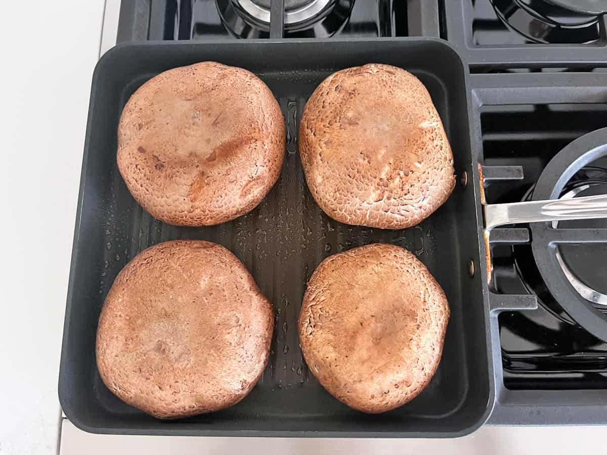 Cooking the portobellos in a stovetop grill pan.