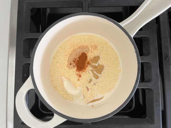 Heating heavy cream and spices in a saucepan.