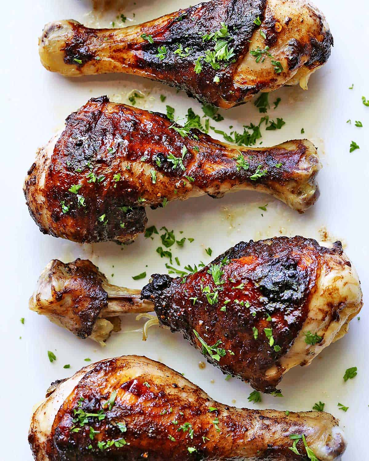 Jerk chicken is served on a white plate.