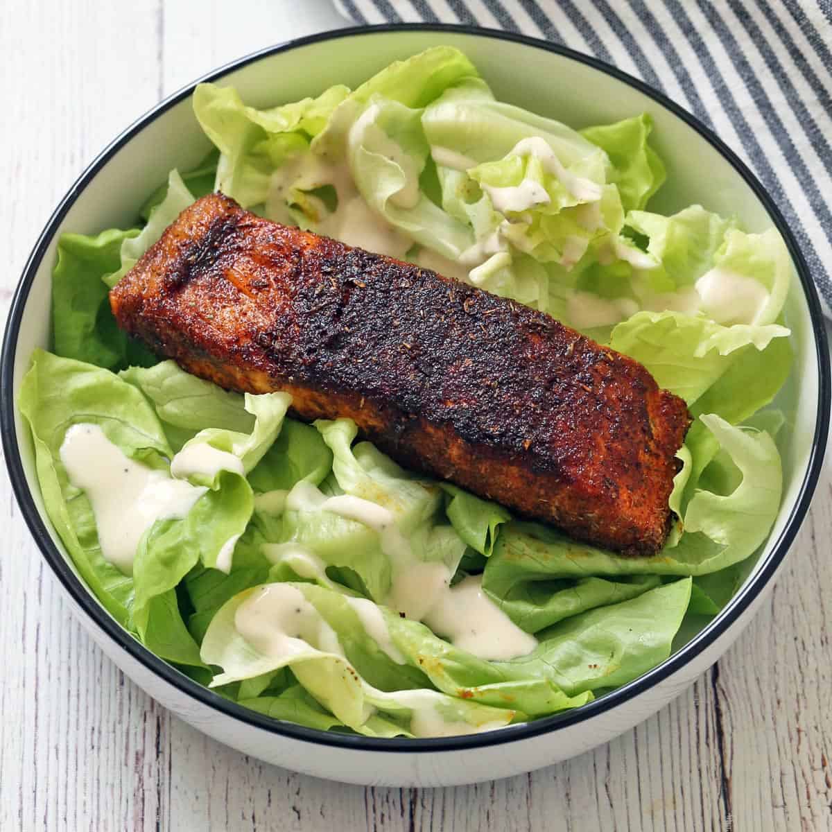 Blackened salmon leftovers are served on a salad.